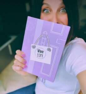 Mujer sosteniendo el libro Vive EOP!! en un entorno acogedor.