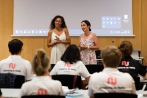Dues dones parlant davant d'un grup en una reunió a Andorra la Vella.