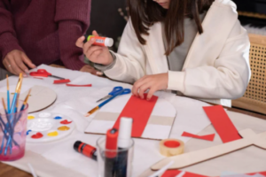 Niña creando un minillibre de pallasso en un taller de Carnaval