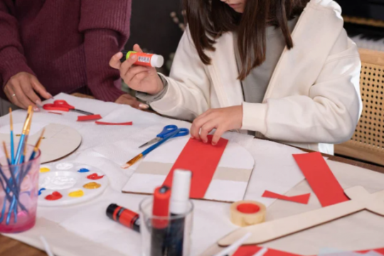 Niña creando un minillibre de pallasso en un taller de Carnaval