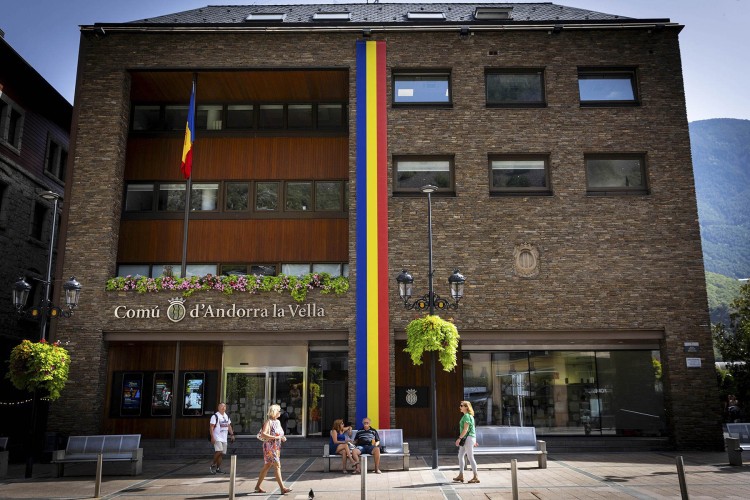 Edificio del Comú d'Andorra la Vella con personas en la plaza