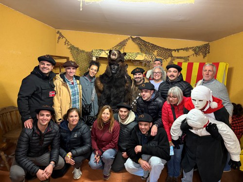 Grupo de personas en la Festa de l'Os con un disfraz de oso en Andorra