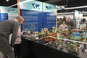 Visitants observant diorames urbans en l'exposició Ciutats a escala humana