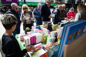 Personas revisando libros en un mercado durante la Fira de Sant Jordi