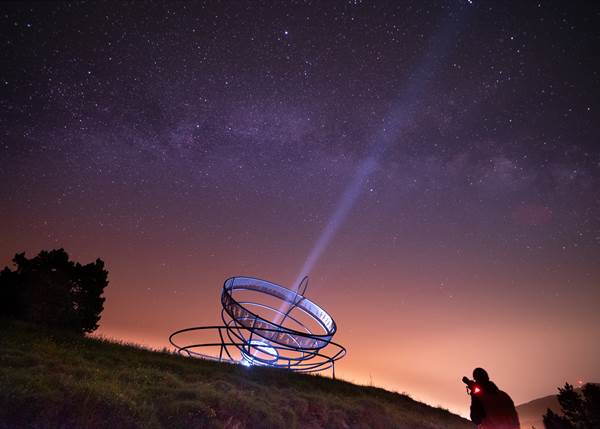Vista nocturna de la Massana con un observatorio y estrellas brillantes