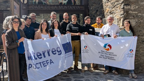 Grupo de personas sosteniendo banderas en el seminario del proyecto POCTEFA en Ordino