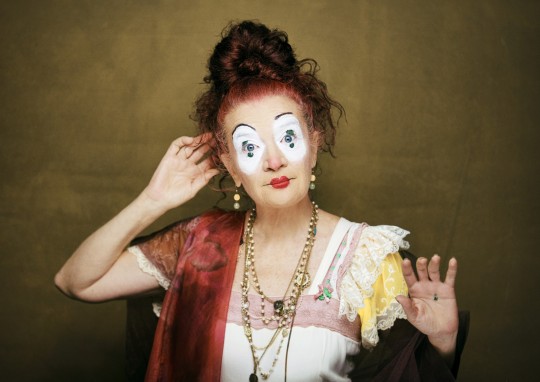 Pallassa Winnie con maquillaje y vestuario colorido en el teatro.