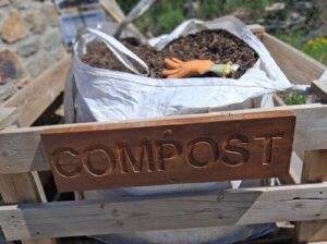 Punto de recogida de compost con letrero en madera