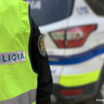 Policía de Andorra con chaleco amarillo y vehículo patrullero de fondo
