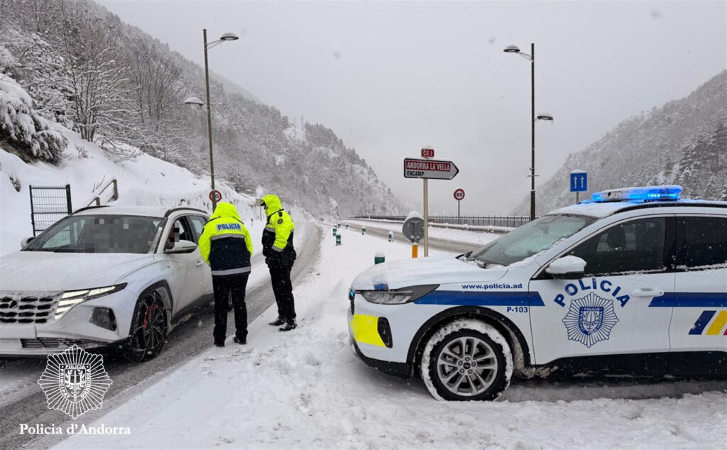Policía de Andorra deteniendo un vehículo en invierno con nieve