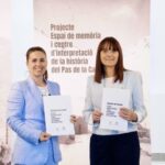 Dos mujeres sosteniendo documentos sobre el centro de interpretación de la historia del Pas de la Casa